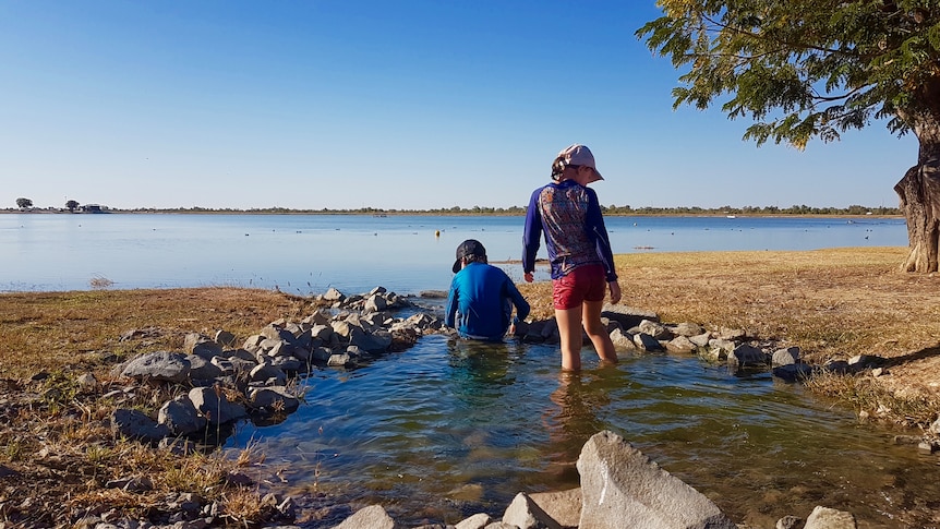 People swim in an outback lagoon.