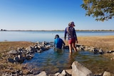 People swim in an outback lagoon.