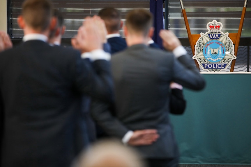 Recruits salute at an official WA Police swearing in ceremony