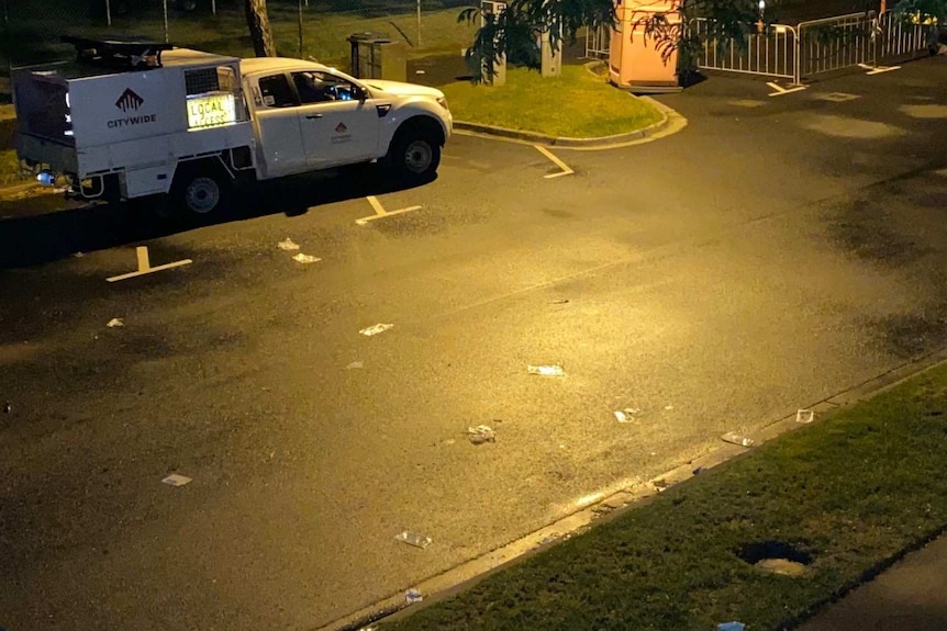 Face masks and other bits of rubbish on a suburban street at night.