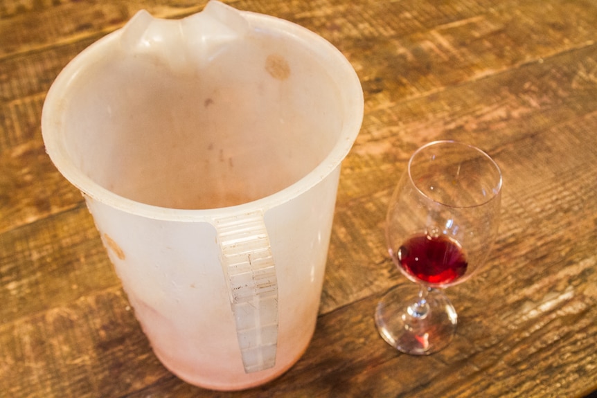 The wine is taken from the barrel to test the colour and taste.