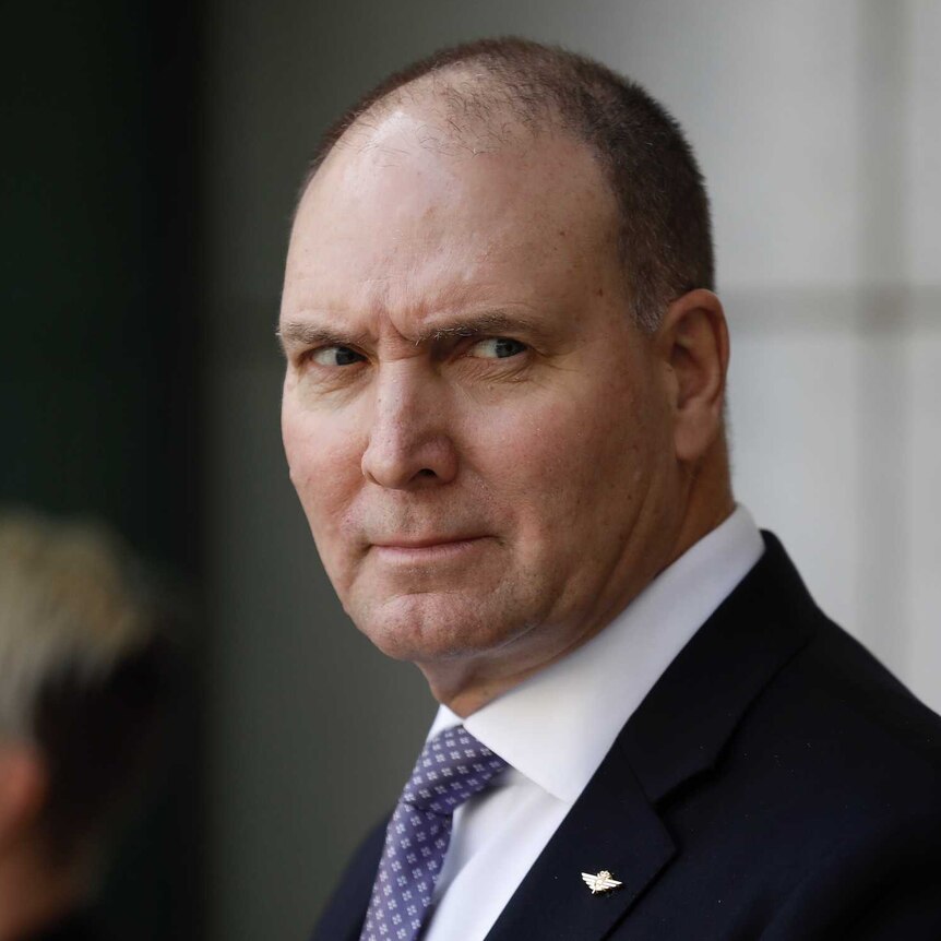 Power, a tall balding man gives some side-eye towards Scott Morrison (not pictured).