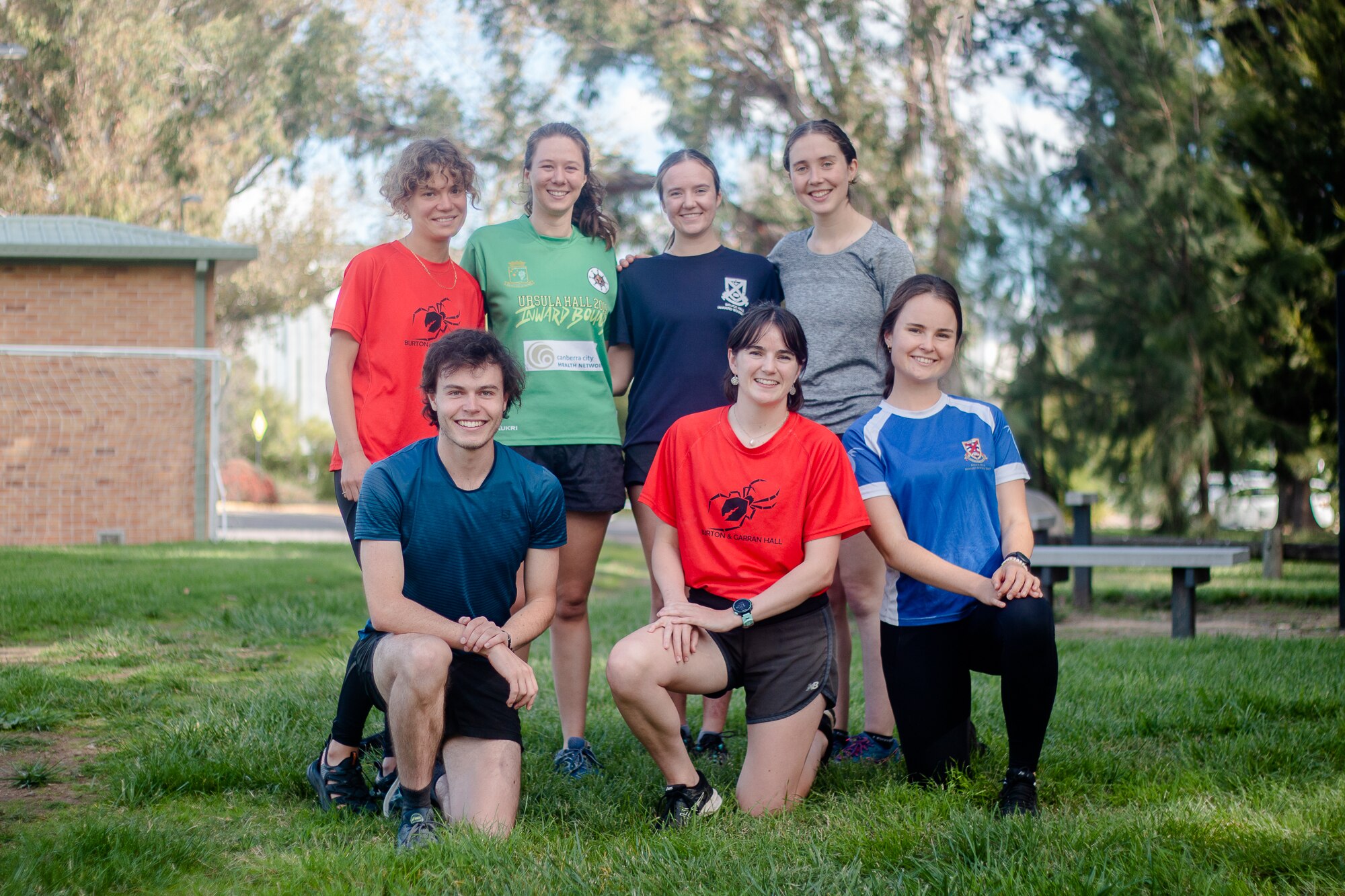 Seven young adults smile and pose for the camera