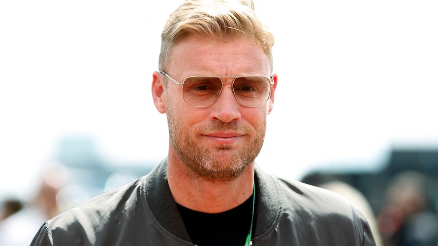 Andrew Flintoff wears a jacket and sunglasses, the background is blurred