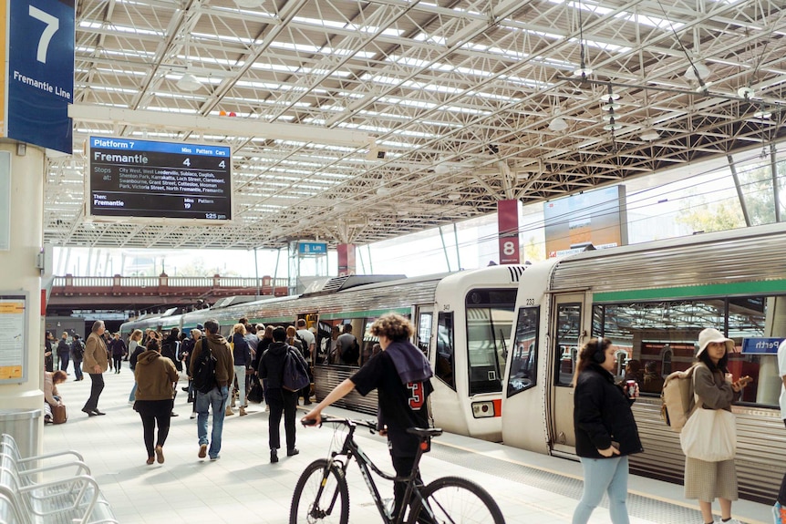 People get on board a train at Perth Station.