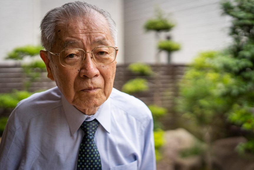 A Japanese man in glasses and a tie 