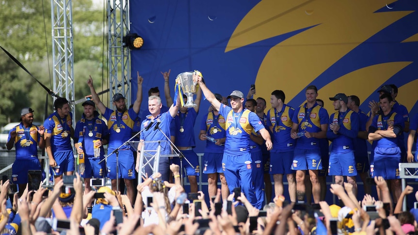 Eagles coach Adam Simpson and captain Shannon Hurn present the cup to the crowd.