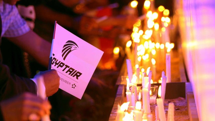 People light candles during a candlelight vigil for the victims of EgyptAir.