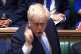 A screenshot from a video shows Boris Johnson pointing his fingers in the House of Commons across the dispatch box.