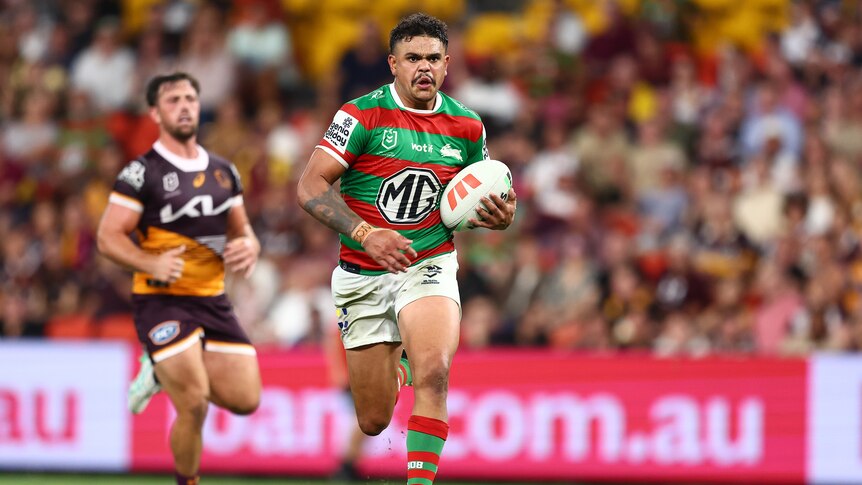 Latrell Mitchell runs with the ball for the SOuth Sydney Rabbitohs in an NRL game against the Brisbane Broncos.