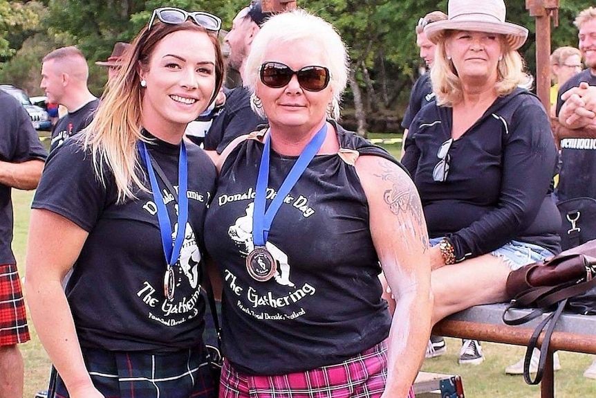 Young woman on the left with her mother on the right wearing medallions.