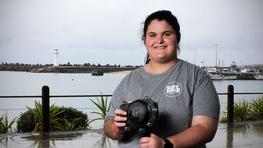 Ocean photographer Shannon Glasson stands at Wollongong Harbour with her under water camera housing.