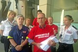 HACSU secretary Tim Jacobson carries a petition seeking action over a paramedics' pay dispute
