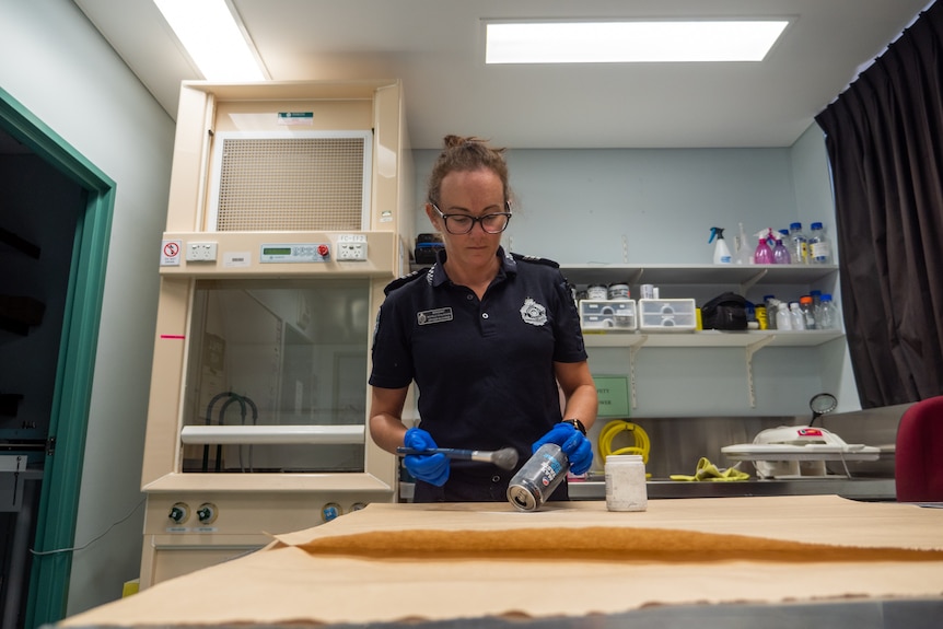 A female police officer in a lab setting.