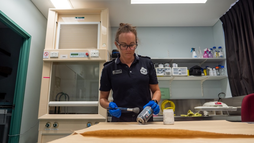 A female police officer in a lab setting.