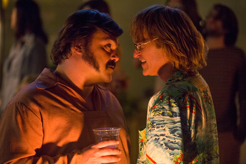 Colour still of Jack Black and Joaquin Phoenix face to face at a party in 2018 film Don't Worry, He Won't Get Far on Foot.