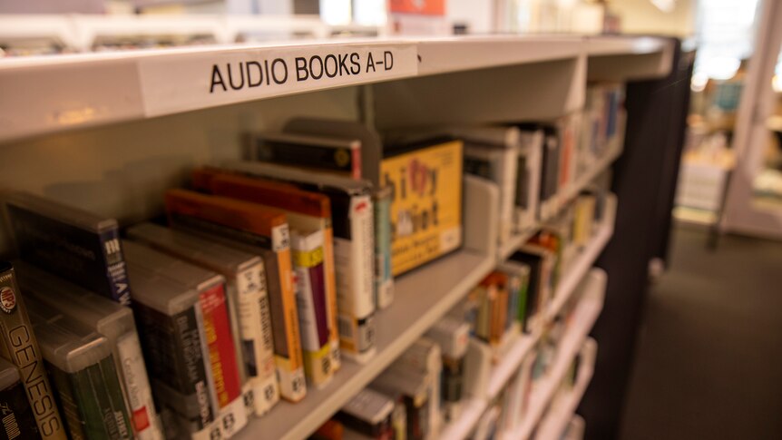 A shelf of cases with the name audio books written above it