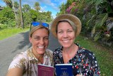 Two women smiling with passports and looking happy on holidays 