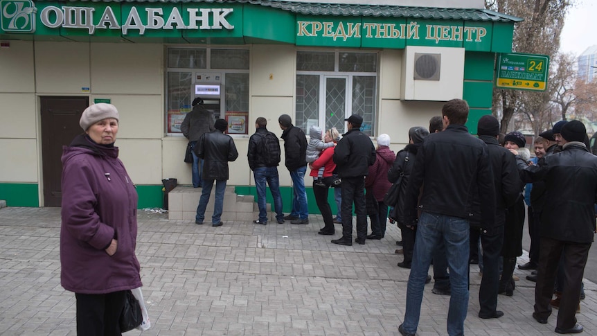 Ukrainians line up to withdraw money from a bank in Donetsk