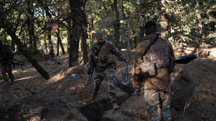 Ukrainian servicemen check the trenches dug by Russian soldiers in a retaken area in Kherson region.