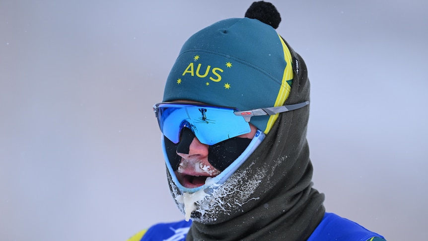 An Australian male cross-country skier with ice forming on the chin of his uniform.