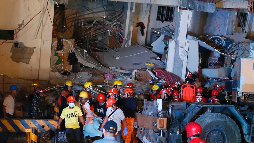 Rescuers carry a victim from a collapsed building