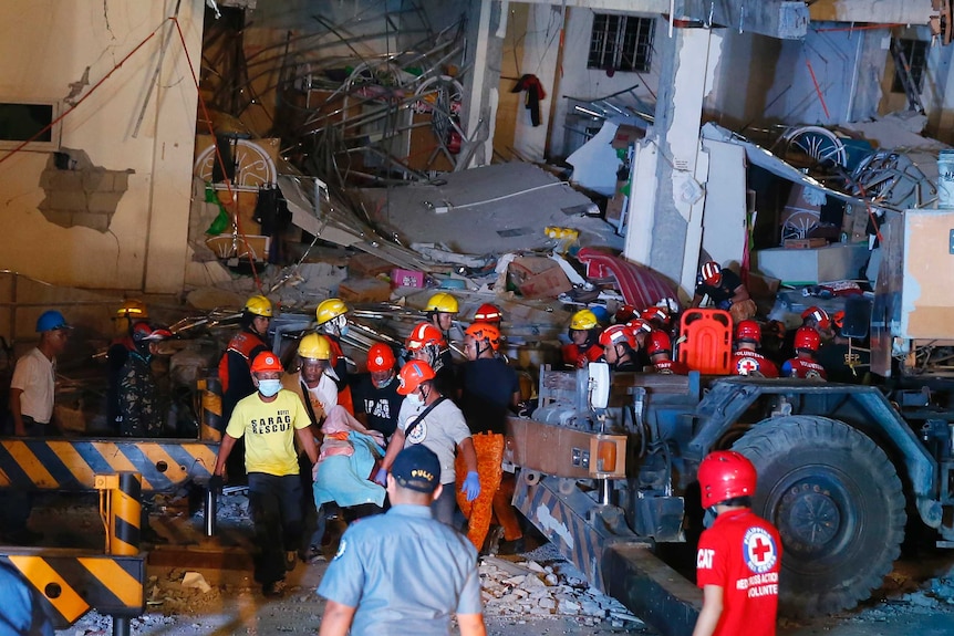 Rescuers carry a victim from a collapsed building