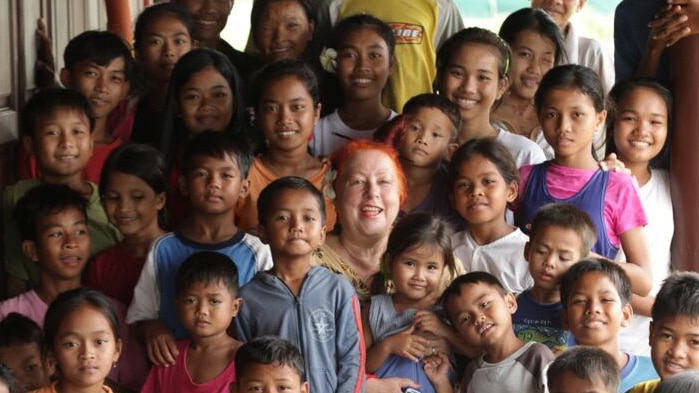 Geraldine Cox surrounded by children at an orphanage