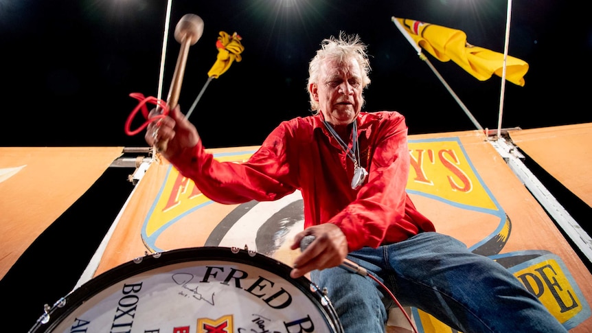 An official bangs a drum, inside the Fred Brophy boxing tent in Mt Isa.