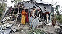 A man removes tin sheets from his damaged house in Bakerganj after cyclone Sidr which hit southern Bangladesh on 15 November ...