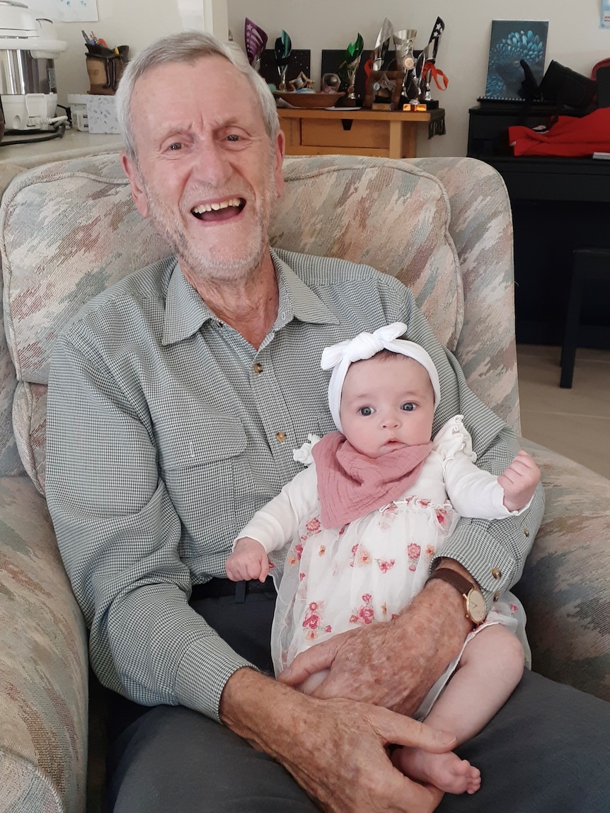 Reverend David Curtis holding his grand daughter