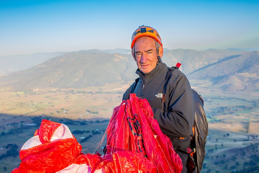 Ken Hutt with helmet and paraglider.