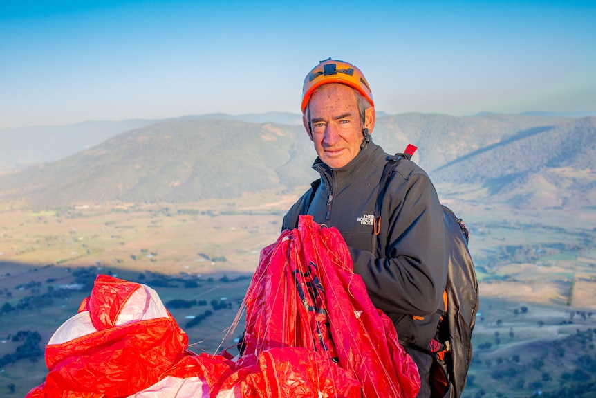 Ken Hutt con casco y parapente.