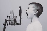 Profile photo of boy singing into microphone