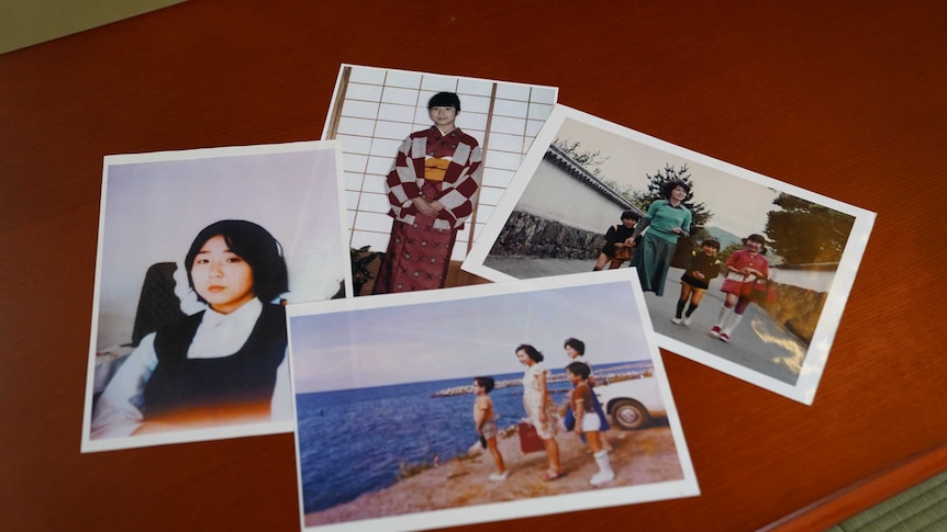 A group of printed photographs of a young Japanese girl on a table