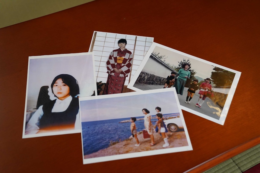 A group of printed photographs of a young Japanese girl on a table