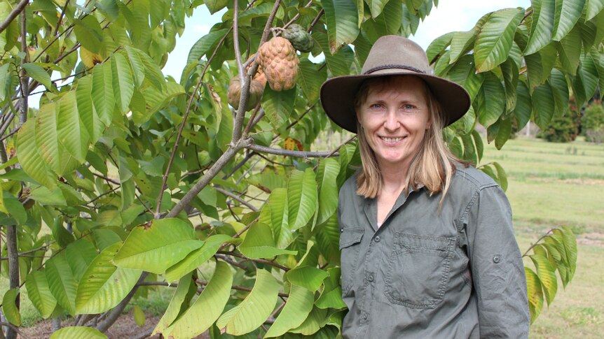 Karen Martin standing next to a PinksBlush custard apple tree.
