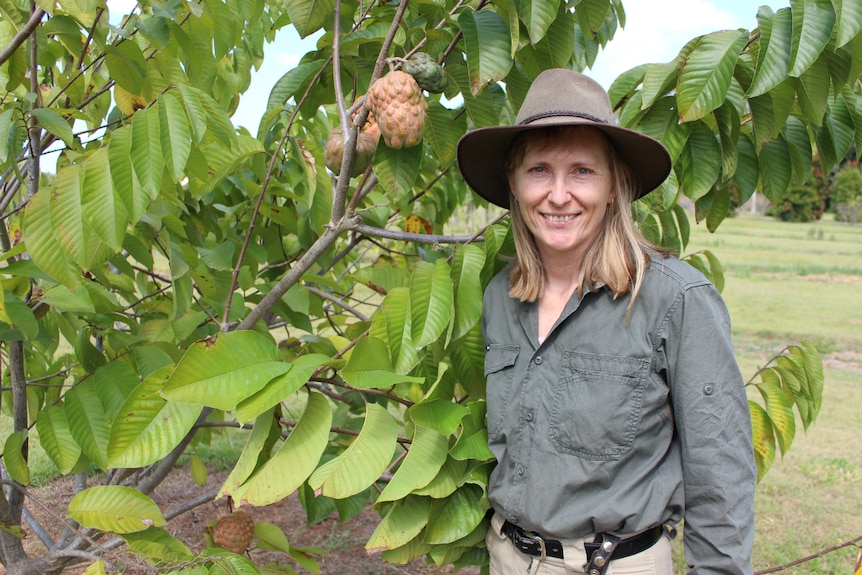 Karen Martin standing next to a PinksBlush custard apple tree.