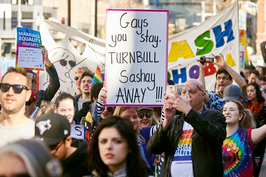 Protester holds sign saying "gays you stay, Turnbull sashay away!!!" during equal marriage rights march in Sydney.