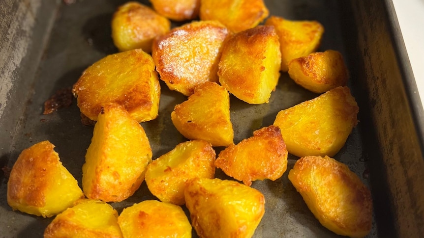 Golden roasted potatoes in a grey baking dish 