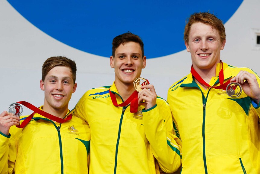 Australia's Mitch Larkin on the podium with silver medallist Josh Beaver (L) and bronze medallist Matson Lawson (R) after the men's 200m backstroke