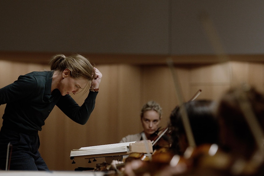 Cate Blanchett deep in concentration as she conducts an orchestra.
