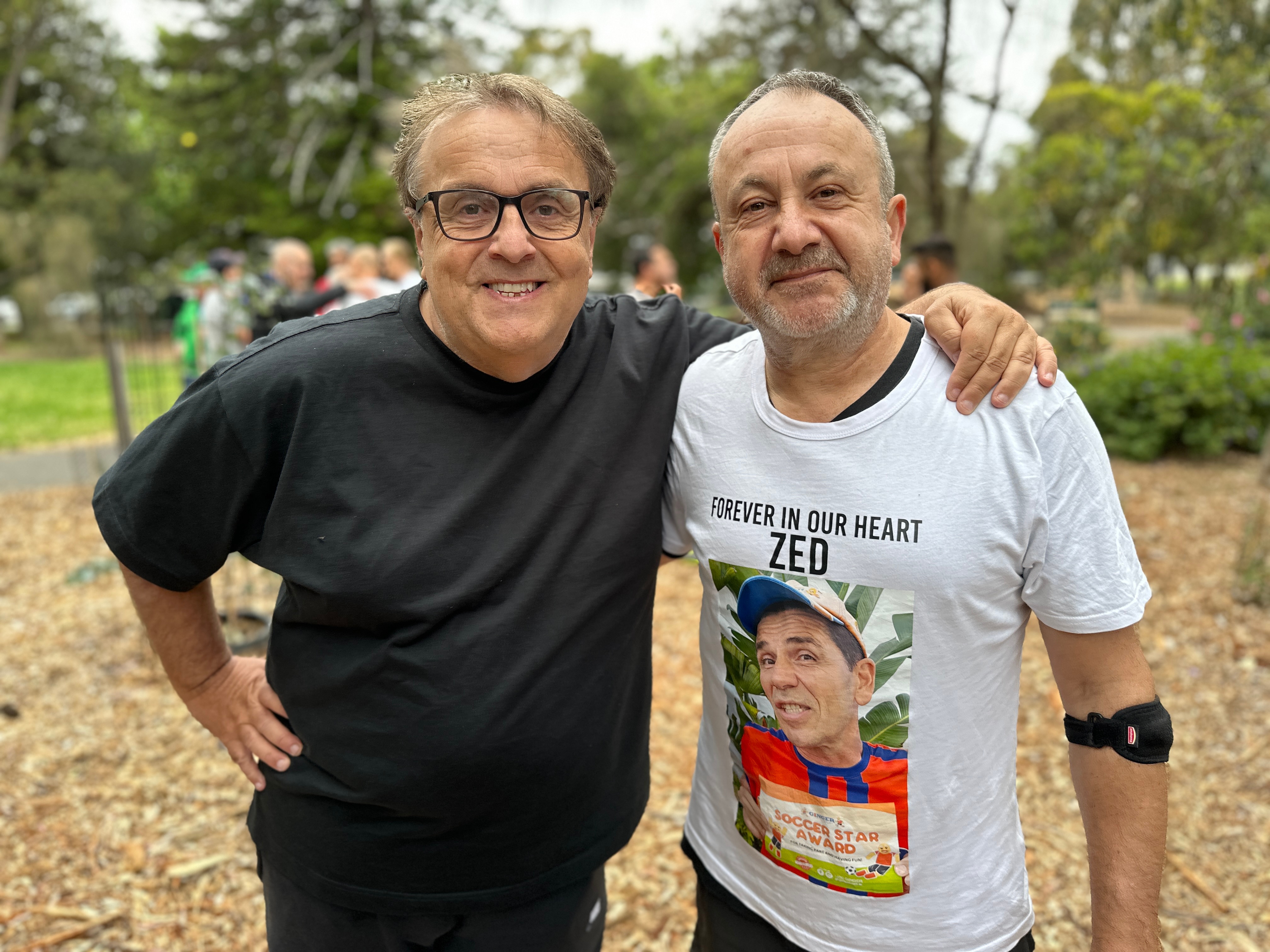 Dos hombres del brazo en el parque.