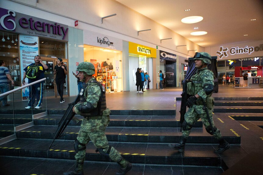 Soldiers walk inside Plaza Las Americas shopping centre