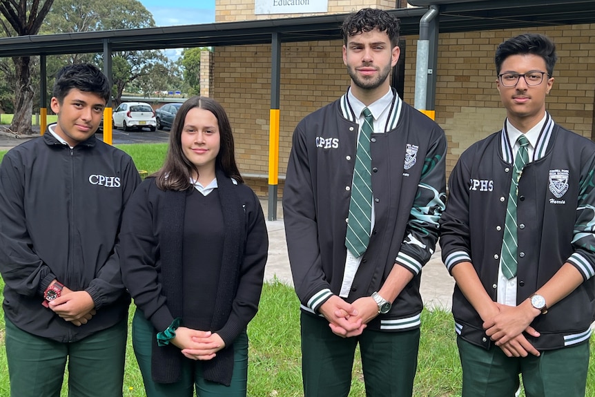 Four school students standing in a row