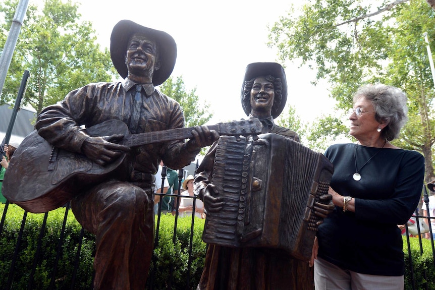 Joy McKean with a bronze statue of Slim Dusty and herself.