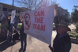 Anti-light rail protestors hold up a banner