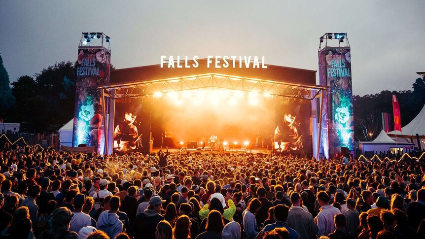A crowd watches a performance on the Falls Festival stage at night.