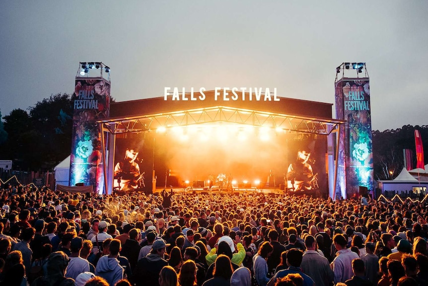 A crowd watches a performance on the Falls Festival stage at night.