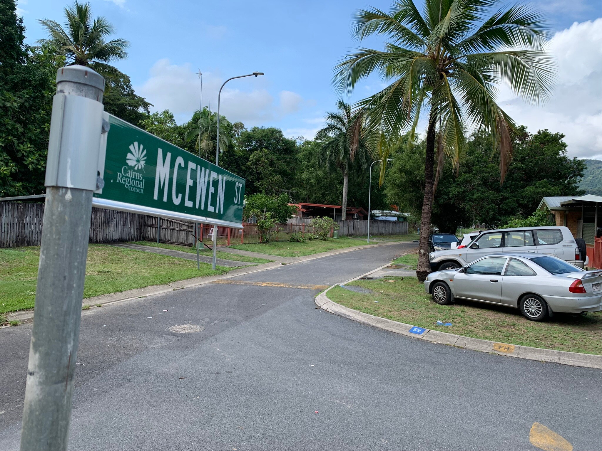 A street sign looking down a suburban street